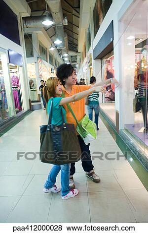 Stock Photo - Couple pointing toward shop window. Fotosearch