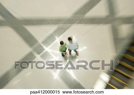 Stock Photography - Couple standing on star-shaped light pattern on floor, high angle view. Fotosearch