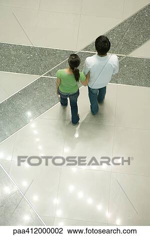 Couple walking past star-shaped light pattern on floor, high angle view View Large Photo Image Stock Image - Couple walking past star-shaped light pattern on floor, high angle view. Fotosearch