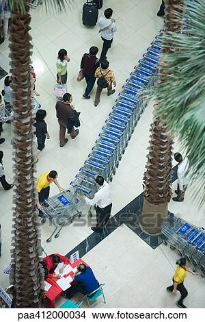 Men standing next to line of shopping carts, high angle view View Large Photo Image Picture - Men standing next to line of shopping carts, high angle view. Fotosearch