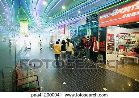 Stock Image - Shoppers walking through mall. Fotosearch