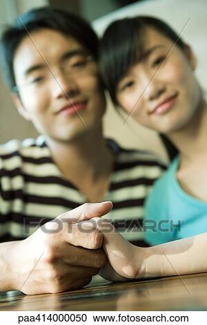 Couple holding hands, focus on hands in foreground View Large Photo Image Stock Image - Couple holding hands, focus on hands in foreground. Fotosearch