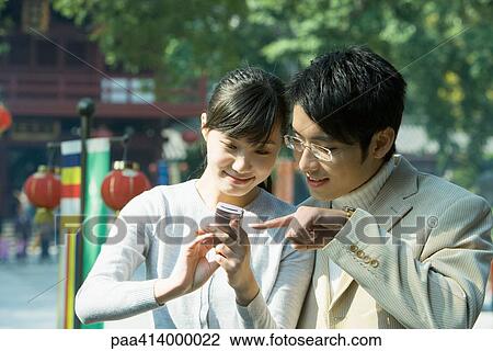 Couple looking at cell phone View Large Photo Image Stock Image - Couple looking at cell phone. Fotosearch