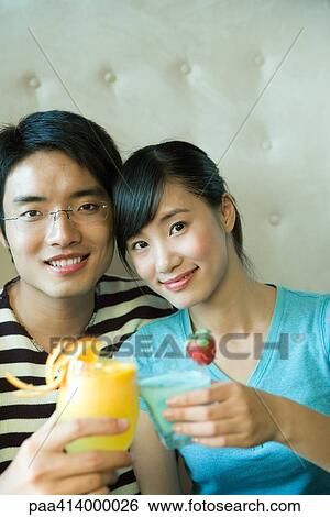 Couple raising glasses together View Large Photo Image Stock Photograph - Couple raising glasses together. Fotosearch