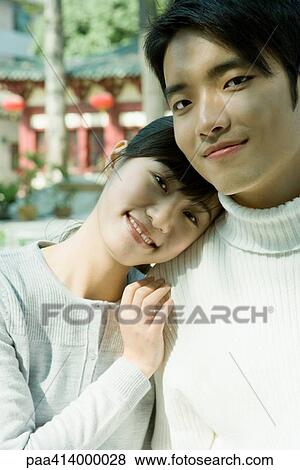 Couple smiling at camera, woman resting head on man's shoulder View Large Photo Image Stock Photo - Couple smiling at camera, woman resting head on man's shoulder. Fotosearch