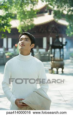 Man looking up, temple in background View Large Photo Image Stock Photograph - Man looking up, temple in background. Fotosearch