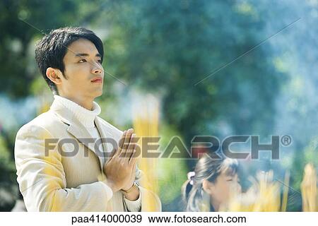 Man praying, incense burning in foreground View Large Photo Image Stock Photo - Man praying, incense burning in foreground. Fotosearch