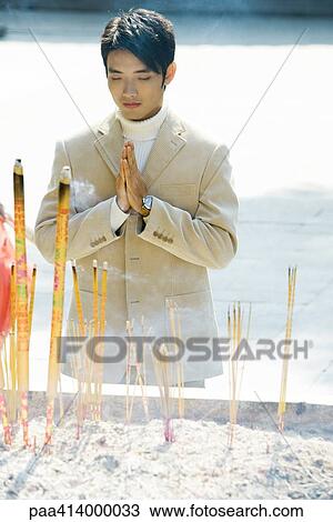 Man praying near incense in temple courtyard View Large Photo Image Stock Image - Man praying near incense in temple courtyard. Fotosearch