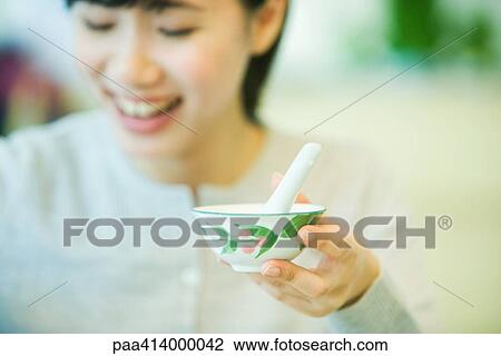 Woman holding up bowl of soup with spoon, focus on bowl in foreground View Large Photo Image Stock Image - Woman holding up bowl of soup with spoon, focus on bowl in foreground. Fotosearch