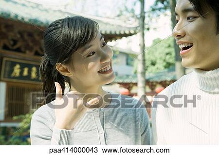 Woman standing next to man, making phone gesture, traditional Chinese building in background View Large Photo Image Stock Image - Woman standing next to man, making phone gesture, traditional Chinese building in background. Fotosearch