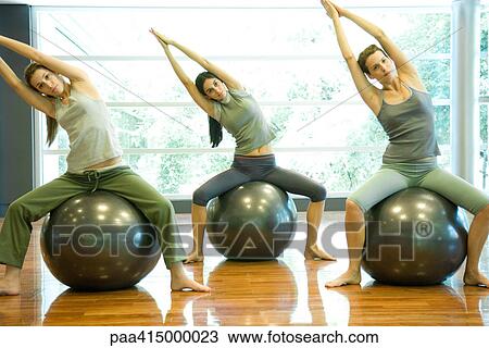 Exercise class doing side stretch on fitness balls View Large Photo Image Stock Image - Exercise class doing side stretch on fitness balls. Fotosearch