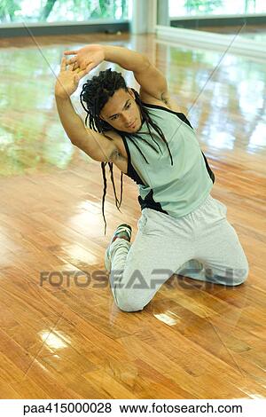 Man kneeling on floor, doing side stretch View Large Photo Image Stock Photo - Man kneeling on floor, doing side stretch. Fotosearch