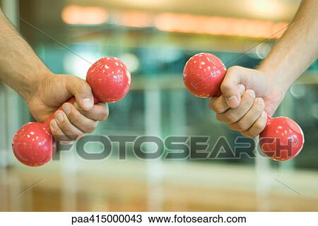 Two hands holding dumbbells, close-up View Large Photo Image Stock Image - Two hands holding dumbbells, close-up. Fotosearch