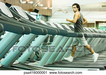 Man running on treadmill in health club View Large Photo Image Stock Image - Man running on treadmill in health club. Fotosearch