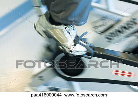 Person peddling exercise bike, close-up, blurred motion View Large Photo Image Picture - Person peddling exercise bike, close-up, blurred motion. Fotosearch