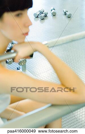 Woman sitting in weight room, focus on dumbbells on floor in background View Large Photo Image Stock Photo - Woman sitting in weight room, focus on dumbbells on floor in background. Fotosearch