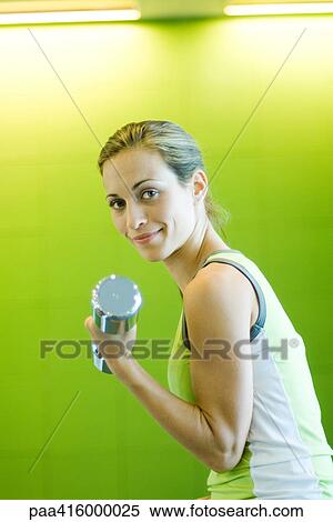 Woman working out with dumbbell View Large Photo Image Stock Photography - Woman working out with dumbbell. Fotosearch
