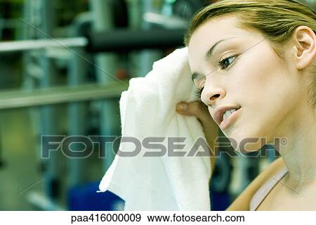Young woman wiping forehead View Large Photo Image Stock Photo - Young woman wiping forehead. Fotosearch