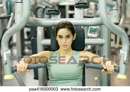 Young woman working out with weight machine View Large Photo Image Stock Image - Young woman working out with weight machine. Fotosearch