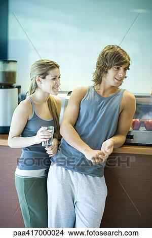Young adults in exercise clothing, taking break in health club cafeteria View Large Photo Image Picture - Young adults in exercise clothing, taking break in health club cafeteria. Fotosearch