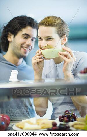 Young adults in exercise clothing, having snack in health club cafeteria View Large Photo Image Picture - Young adults in exercise clothing, having snack in health club cafeteria. Fotosearch