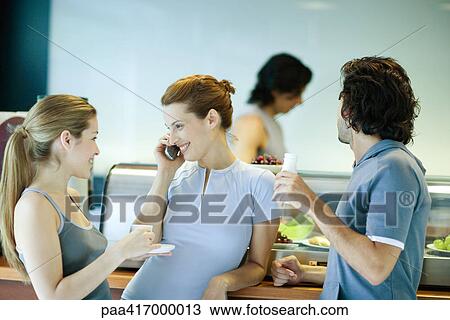 Young adults in exercise clothing, taking break in health club cafeteria View Large Photo Image Stock Image - Young adults in exercise clothing, taking break in health club cafeteria. Fotosearch