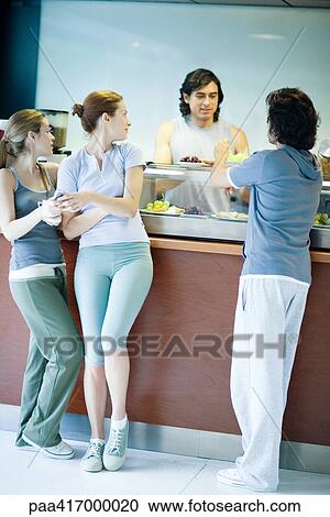 Young adults in exercise clothing, taking break in health club cafeteria View Large Photo Image Stock Image - Young adults in exercise clothing, taking break in health club cafeteria. Fotosearch