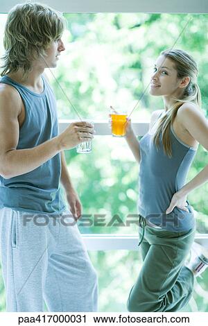 Young adults in exercise clothing, holding drinks and chatting View Large Photo Image Stock Image - Young adults in exercise clothing, holding drinks and chatting. Fotosearch