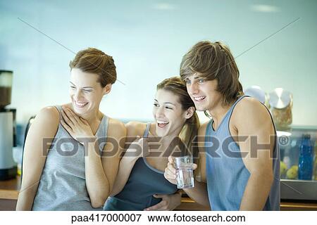 Young adults in exercise clothing, taking break in health club cafeteria View Large Photo Image Stock Photo - Young adults in exercise clothing, taking break in health club cafeteria. Fotosearch