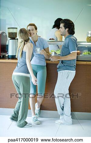 Young adults in exercise clothing, taking break in health club cafeteria View Large Photo Image Stock Photo - Young adults in exercise clothing, taking break in health club cafeteria. Fotosearch