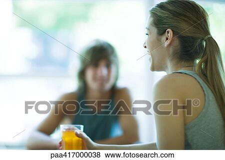 Young adults in exercise clothing, woman holding drink and laughing View Large Photo Image Stock Photo - Young adults in exercise clothing, woman holding drink and laughing. Fotosearch