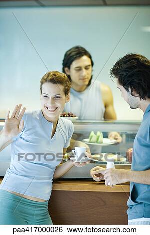 Young adults in exercise clothing, taking break in health club cafeteria View Large Photo Image Stock Photograph - Young adults in exercise clothing, taking break in health club cafeteria. Fotosearch