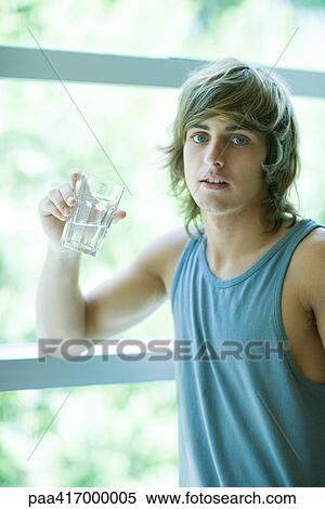 Young man in exercise clothing drinking glass of water View Large Photo Image Stock Photography - Young man in exercise clothing drinking glass of water. Fotosearch