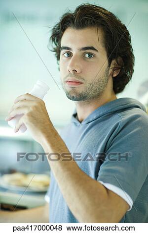 Young man in exercise clothing, having a drink in health club cafeteria View Large Photo Image Stock Photo - Young man in exercise clothing, having a drink in health club cafeteria. Fotosearch