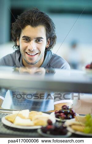 Stock Photograph - Young man in exercise clothing in health club cafeteria. Fotosearch