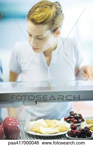 Young woman choosing snack in health club cafeteria View Large Photo Image Stock Photograph - Young woman choosing snack in health club cafeteria. Fotosearch