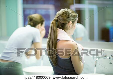 Stock Photo - Women in public restroom, facing mirror. Fotosearch