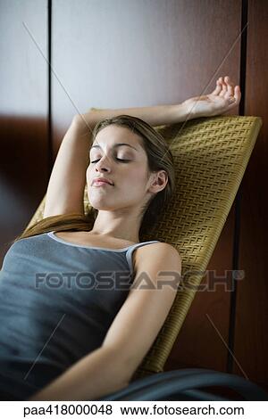 Young woman relaxing in lounge chair View Large Photo Image Stock Photo - Young woman relaxing in lounge chair. Fotosearch