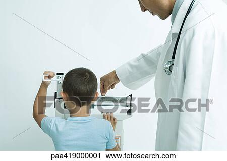 Boy standing on scale at doctor's office View Large Photo Image Stock Image - Boy standing on scale at doctor's office. Fotosearch