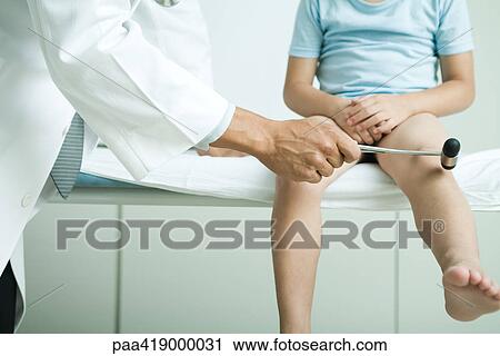 Stock Image - Doctor checking child's reflexes. Fotosearch