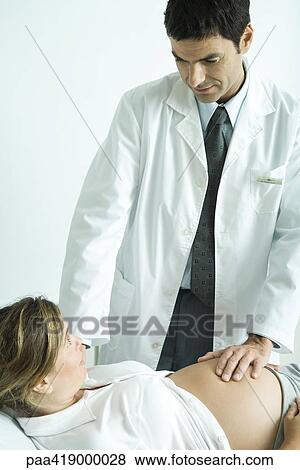 Stock Photo - Doctor examining pregnant woman. Fotosearch
