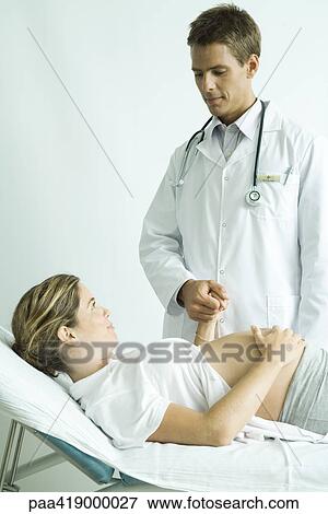 Doctor holding pregnant woman's hand View Large Photo Image Stock Photo - Doctor holding pregnant woman's hand. Fotosearch