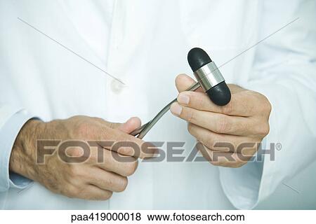 Doctor holding reflex hammer, close-up of hands View Large Photo Image Stock Photo - Doctor holding reflex hammer, close-up of hands. Fotosearch