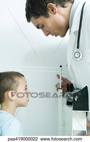 Doctor measuring boy's height View Large Photo Image Stock Image - Doctor measuring boy's height. Fotosearch