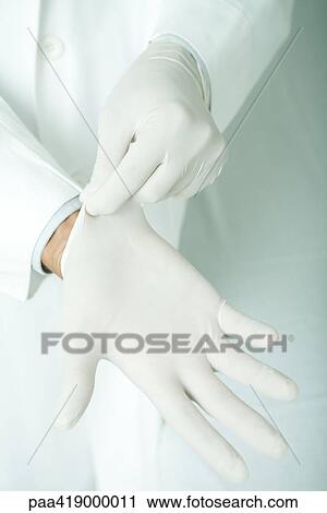 Doctor putting on latex gloves View Large Photo Image Stock Image - Doctor putting on latex gloves. Fotosearch