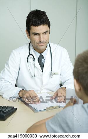 Doctor sitting across from child View Large Photo Image Stock Image - Doctor sitting across from child. Fotosearch