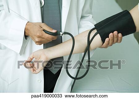 Doctor taking patient's blood pressure View Large Photo Image Stock Image - Doctor taking patient's blood pressure. Fotosearch
