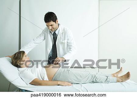 Pregnant woman being examined by doctor View Large Photo Image Stock Photograph - Pregnant woman being examined by doctor. Fotosearch