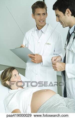 Two doctors speaking to pregnant woman View Large Photo Image Stock Photo - Two doctors speaking to pregnant woman. Fotosearch