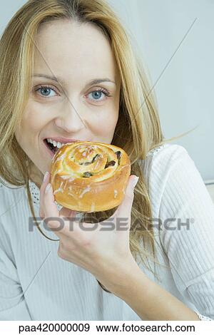Woman eating pastry, smiling at camera View Large Photo Image Stock Photo - Woman eating pastry, smiling at camera. Fotosearch